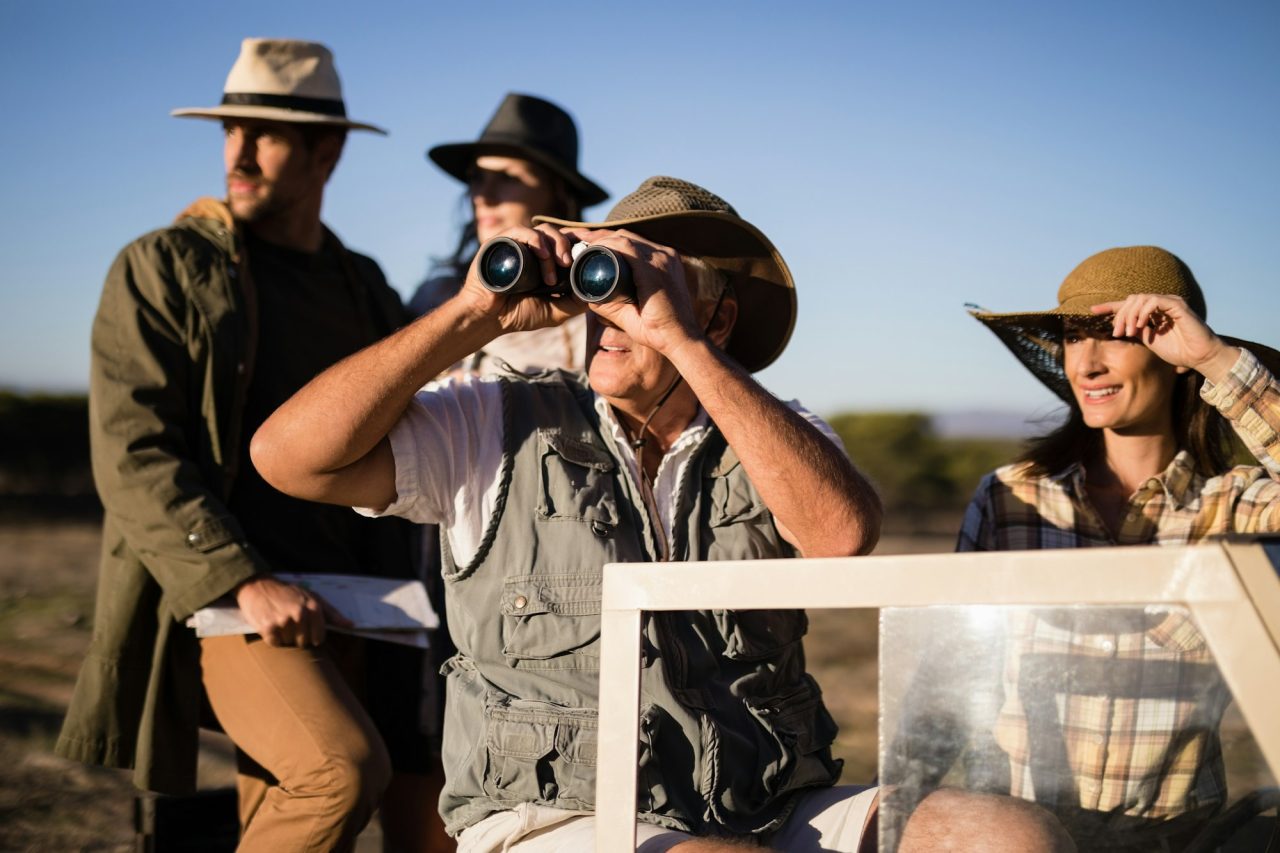 Happy friends enjoying in vehicle during safari vacation